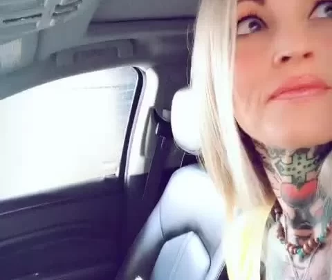 Blonde girl plays with herself in a car