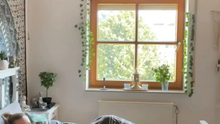 Blonde girl lies on bed, looks at camera