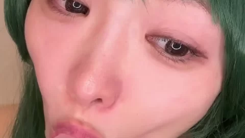 Asian girl with green dress gives herself a blowjob
