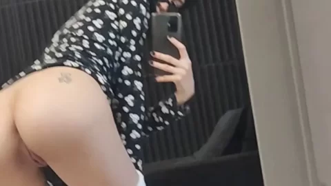 Asian girl with tattoo on buttock bends over in bathroom