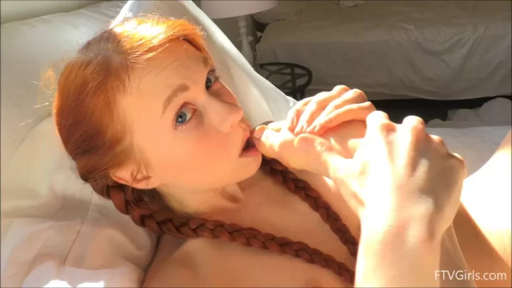 Redhead teen sucks own toes on bed