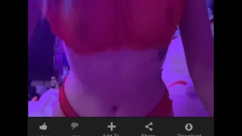 Blonde girl with tattoo posing in purple lit bedroom